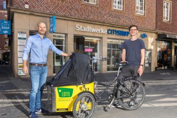 Das kostenlose Lastenrad Lotte kann bis Ende Juli im CityShop der Stadtwerke ausgeliehen werden. Darüber freuen sich Steffen Schmidt von der Lastenrad-Initiative „Lasse“ (r.) und CityShop-Leiter Marcel Braulik. (Foto: Stadtwerke)