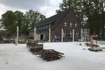 Blick auf die Baustelle der neuen Kita: Das Bestandsgebäude (Hintergrund) wird entkernt. Beim Anbau (Vordergrund) sind bereits die Bodenplatte und erste Stützen zu sehen. Foto: Wohn+Stadtbau.