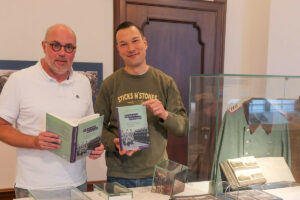 Thomas Köhler (li.) und Peter Römer zusammen mit dem Sammelband „Polizei und Holocaust“ in der Ausstellung. (Foto: Villa ten Hompel)