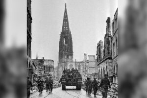 Die ersten Friedenstage im zerstörten Münster: Britische und amerikanische Soldaten ziehen am 4. April 1945 über den Prinzipalmarkt. Mit der Programmreihe „80 Jahre Frieden?“ beleuchtet die Stadt Münster die Zeit nach dem Kriegsende. (Foto: mperial War Museum, London / Stadtmuseum Münster)