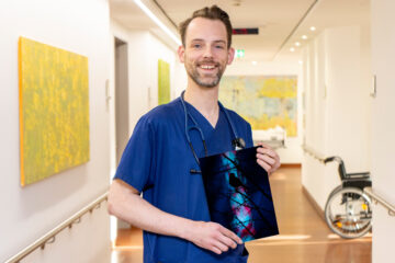 Dr. Christian Brinkmann mit seinem Foto der Amsel vor den Lichtern des Send. (Foto: Raphaelsklinik)